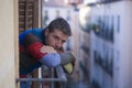 Urban lifestyle emotional portrait of 30s handsome man sad and depressed at home balcony leaning upset feeling desperate suffering Royalty Free Stock Photo