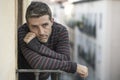 Urban lifestyle emotional portrait of 30s handsome man sad and depressed at home balcony leaning upset feeling desperate suffering Royalty Free Stock Photo