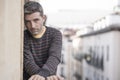 Urban lifestyle emotional portrait of 30s handsome man sad and depressed at home balcony leaning upset feeling desperate suffering Royalty Free Stock Photo