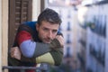 Urban lifestyle emotional portrait of 30s handsome man sad and depressed at home balcony leaning upset feeling worried suffering Royalty Free Stock Photo