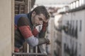 Urban lifestyle emotional portrait of 40s handsome man sad and depressed at home balcony leaning upset feeling worried suffering Royalty Free Stock Photo