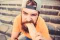 Urban lifestyle nutrition. Junk food. Carefree hipster eat junk food while sit stairs. Guy eating hot dog. Snack for Royalty Free Stock Photo