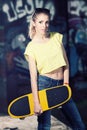 Urban lifestyle shot. Beautiful funky girl with skateboard