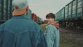 Urban Love Story. Date Young Couple On The Railroad. Wagons Of Trains Surround Them. Royalty Free Stock Photo