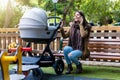 Urban mother with her newborn baby in the park talking on her mobile phone Royalty Free Stock Photo