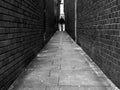 Urban, Narrow brick alleyway. A textured contrasting walkway that tapers to a vanishing point. Royalty Free Stock Photo