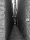 Urban, Narrow brick alleyway. A textured contrasting walkway that tapers to a vanishing point. Royalty Free Stock Photo