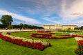 Urban nature: privy garden in majestic Schonbrunn palace, Vienna Austria against orange houses and dramatic sky Royalty Free Stock Photo