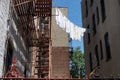 Urban Outdoor Clothes Line with White Clothes and Fire Escapes on New York City Apartment Buildings Royalty Free Stock Photo