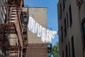 Urban Outdoor Clothes Line with White Clothes and Fire Escapes on New York City Apartment Buildings Royalty Free Stock Photo