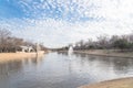 Urban park bare tree, altocumulus cloud, fountain lake in Texas, USA