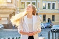 Urban portrait of beautiful young blonde woman with long hair flying in wind Royalty Free Stock Photo
