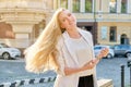 Urban portrait of beautiful young blonde woman with long hair flying in wind Royalty Free Stock Photo