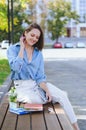 Urban portrait of young business woman in eye glasses, t- shirt, trousers is walking in the city street. Drinking healthy drink Royalty Free Stock Photo