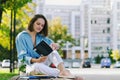 Urban portrait of young business woman in eye glasses, t- shirt, trousers is walking in the city street. Drinking healthy drink Royalty Free Stock Photo