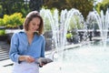 Urban portrait of young elegant business woman in eye glasses and casual clothes in city. Woman walking in green park, relaxing Royalty Free Stock Photo