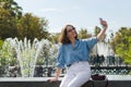 Urban portrait of young elegant business woman in eye glasses and casual clothes in city. Woman walking in green park, relaxing Royalty Free Stock Photo