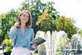 Urban portrait of young elegant business woman in eye glasses and casual clothes in city. Woman walking in green park, relaxing Royalty Free Stock Photo