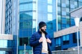 Urban portrait of young happy elegant business man in winter casual clothes, jeans, sweater. Walking in street, talking on phone Royalty Free Stock Photo