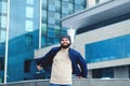 Urban portrait of young happy elegant business man in winter casual clothes, jeans, sweater. Walking in street, talking on phone Royalty Free Stock Photo