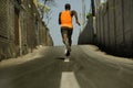 Back view of athletic black African American professional sport man running training hard outdoors on asphalt road during jogging Royalty Free Stock Photo