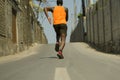 Back view of athletic black afro American professional sport man running training hard outdoors on asphalt road during jogging Royalty Free Stock Photo