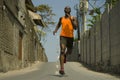 Urban runner workout . Young attractive and athletic black African American man running outdoors on asphalt road training hard Royalty Free Stock Photo