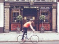 Urban scene of a cyclist walking in front of an English pub