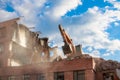 Urban scene. Dismantling of a house. Building demolition and crashing by machinery for new construction. Industry Royalty Free Stock Photo