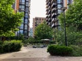Urban scene from ground level, lined pathway with lush greenery and scattered spherical objects leading to a modern apartment Royalty Free Stock Photo