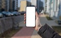 Urban smartphone use, person holding mobile phone with touchscreen, cityscape mock up. Digital Royalty Free Stock Photo