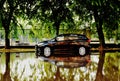 urban street scene after heavy storm. flooded road. car partly in deep water. strong reflection