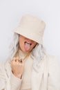 Urban street style Blonde. Details of everyday look. Casual beige outfit and accessories. Bucket hat, chain and rings. Trendy