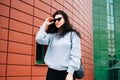 Urban style concept. Close up portrait of fashionable teenage girl in sunglasses posing on city street in summer. Glamour young Royalty Free Stock Photo