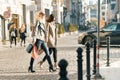 Urban style, two young smiling fashionable women walking along a city street with shopping bags, sunny autumn day, golden hour Royalty Free Stock Photo