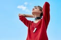 Urban Style. Young stylish woman standing outdoors holding head breathing freedom joyful bottom view Royalty Free Stock Photo