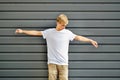 Slim hipster with two raised arms near the gray wall in a b Royalty Free Stock Photo