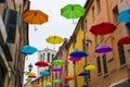 olorful umbrellas floating in the sky above the ancient UNESCO listed town centre of Ferrara, Italy.