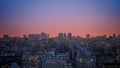 Urban view of the sky at sunset revealing evening lights and shadows of buildings.