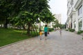 Urban walking road among green tree in modern apartment buildings in big city