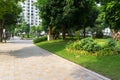 Urban walking road among green tree in modern apartment buildings in big city