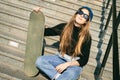 Urban woman with skate. Hipster girl with skateboard in city. Extreme sport and emotions concept. Alternative lifestyle. Stylish Royalty Free Stock Photo