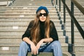 Urban woman with skate. Hipster girl with skateboard in city. Extreme sport and emotions concept. Alternative lifestyle. Stylish Royalty Free Stock Photo