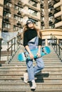 Urban woman with skate. Hipster girl with skateboard in city. Extreme sport and emotions concept. Alternative lifestyle. Stylish Royalty Free Stock Photo