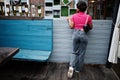 Urban young african american woman in pink top and grey jeans and sunglasses with handbag. Afro fashion chic women