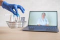 Urchase of medicines using the computer application for home delivery. Pharmacist on laptop screen. A hand in a rubber Royalty Free Stock Photo