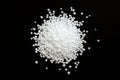 Urea fertilizer on a black background, top view. White mineral fertilizer balls - urea carbamide. Urea nitrogen