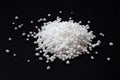 Urea fertilizer on a black background, top view. White mineral fertilizer balls - urea carbamide. Urea nitrogen fertilizer on a