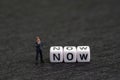 Urgency, stop postpone and procrastination, motivation concept, miniature figure businessman standing with white cube with Royalty Free Stock Photo