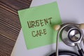 Urgent Care write on sticky notes isolated on Wooden Table